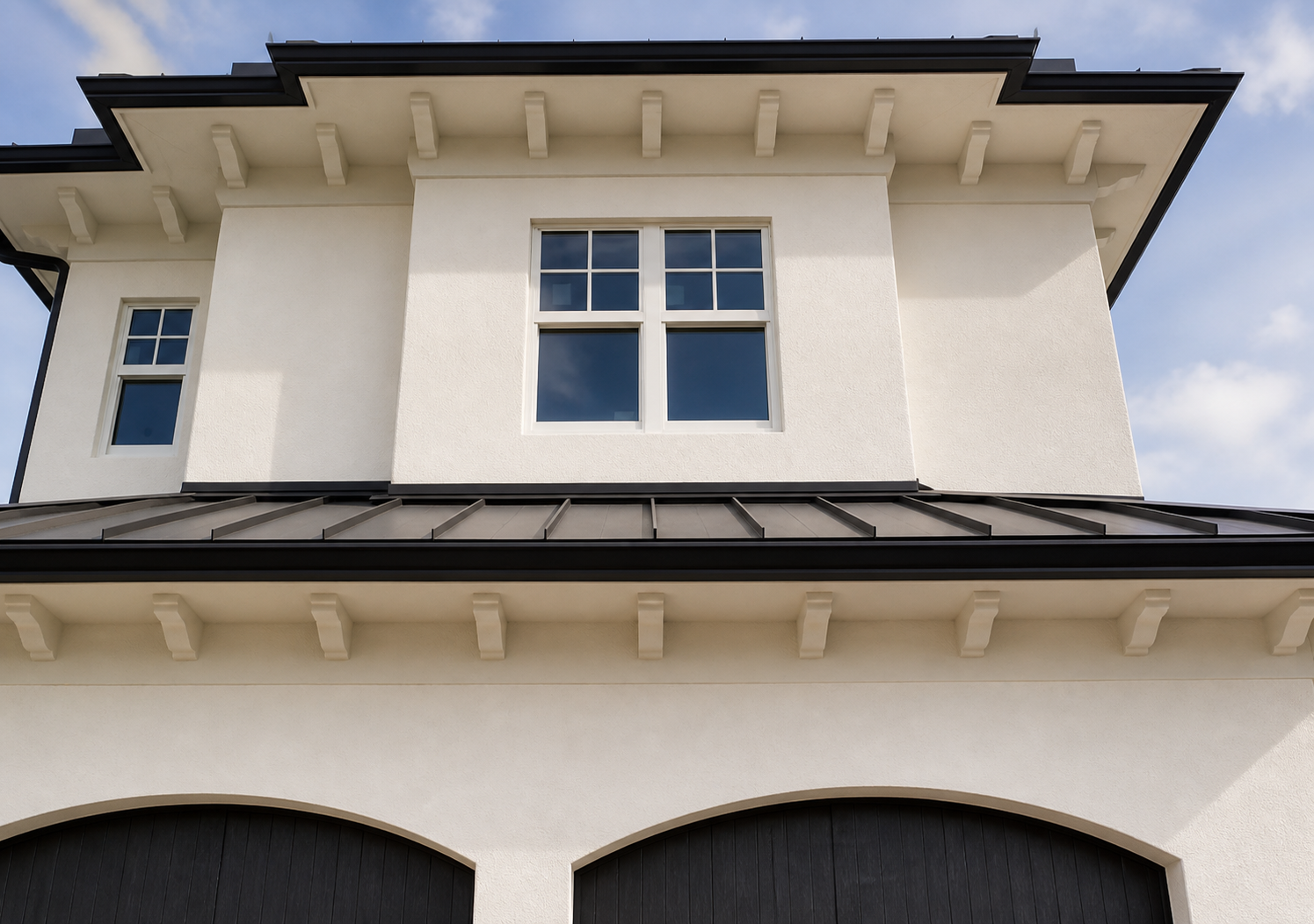 Repeating decorative brackets installed beneath the rooflines of a white residence